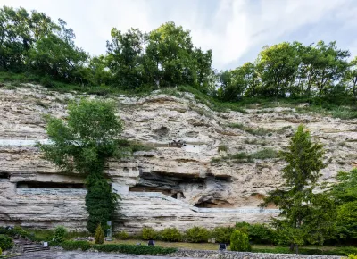 A medieval cave monastery carved into a limestone cliff